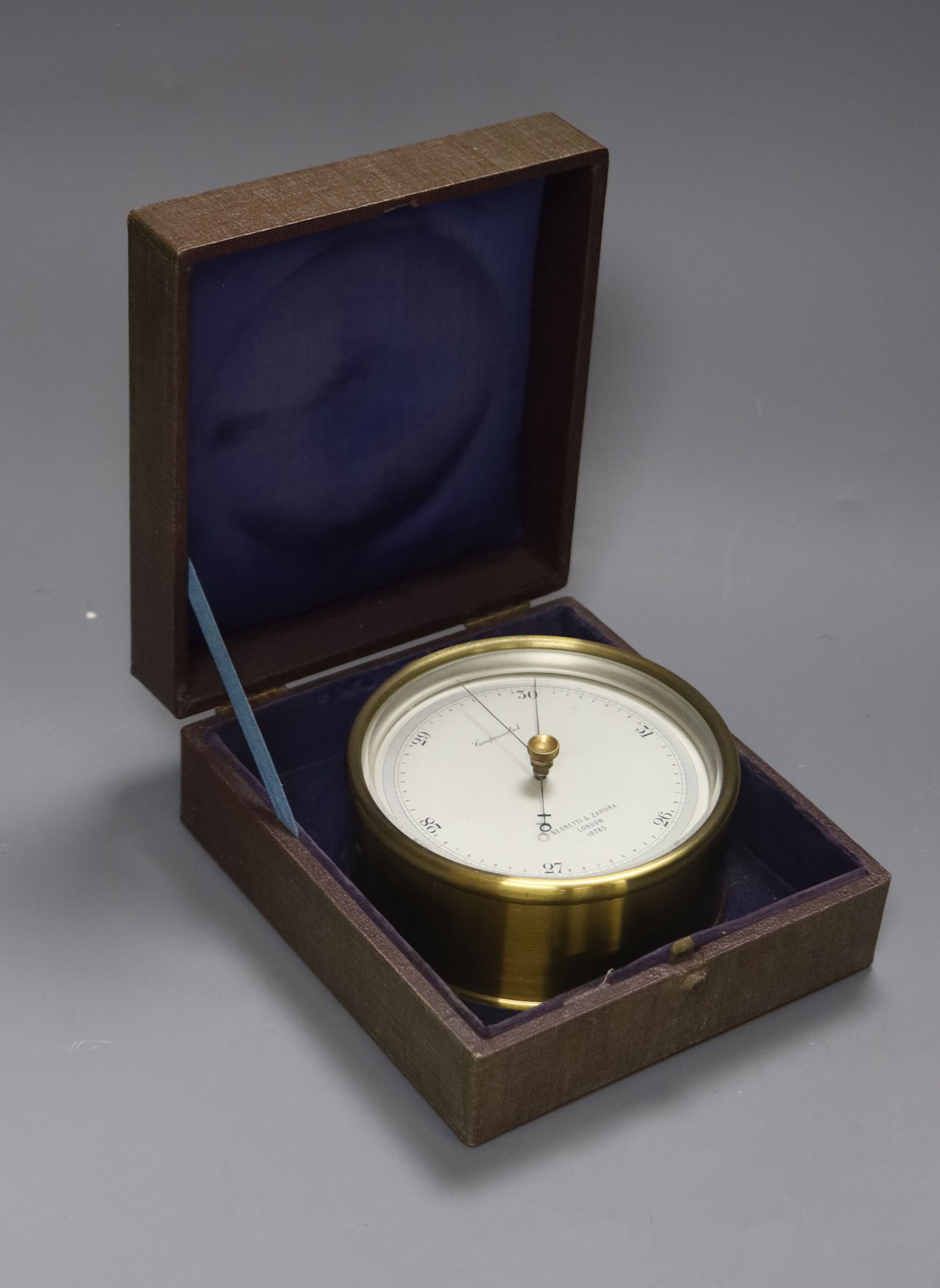 A cased Negretti & Zambra brass cased barometer, diameter 12cm